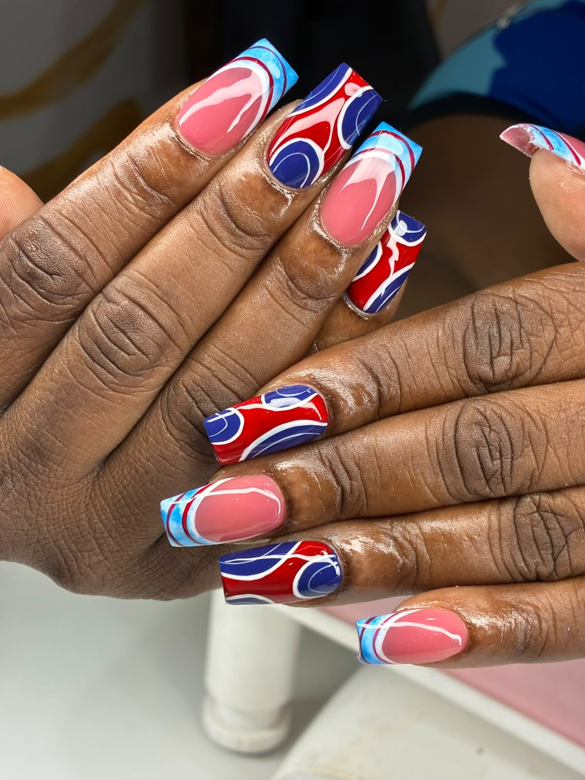 Pink square nails with red, blue and white swirl art by Lex
